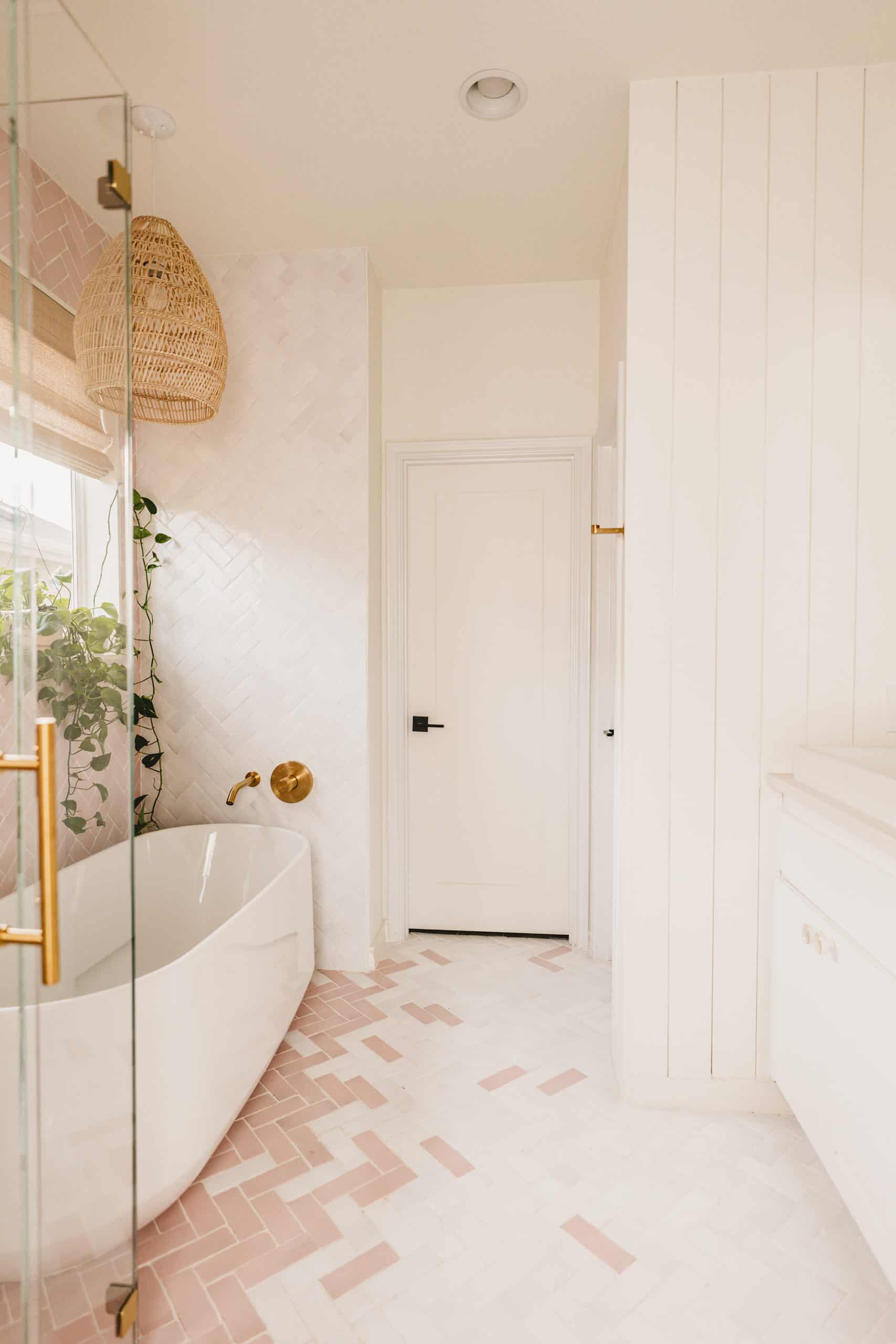 Boho Modern Bathroom Design | soaking bathtub | Kohler | herringbone pink and white rectangle tile | plants